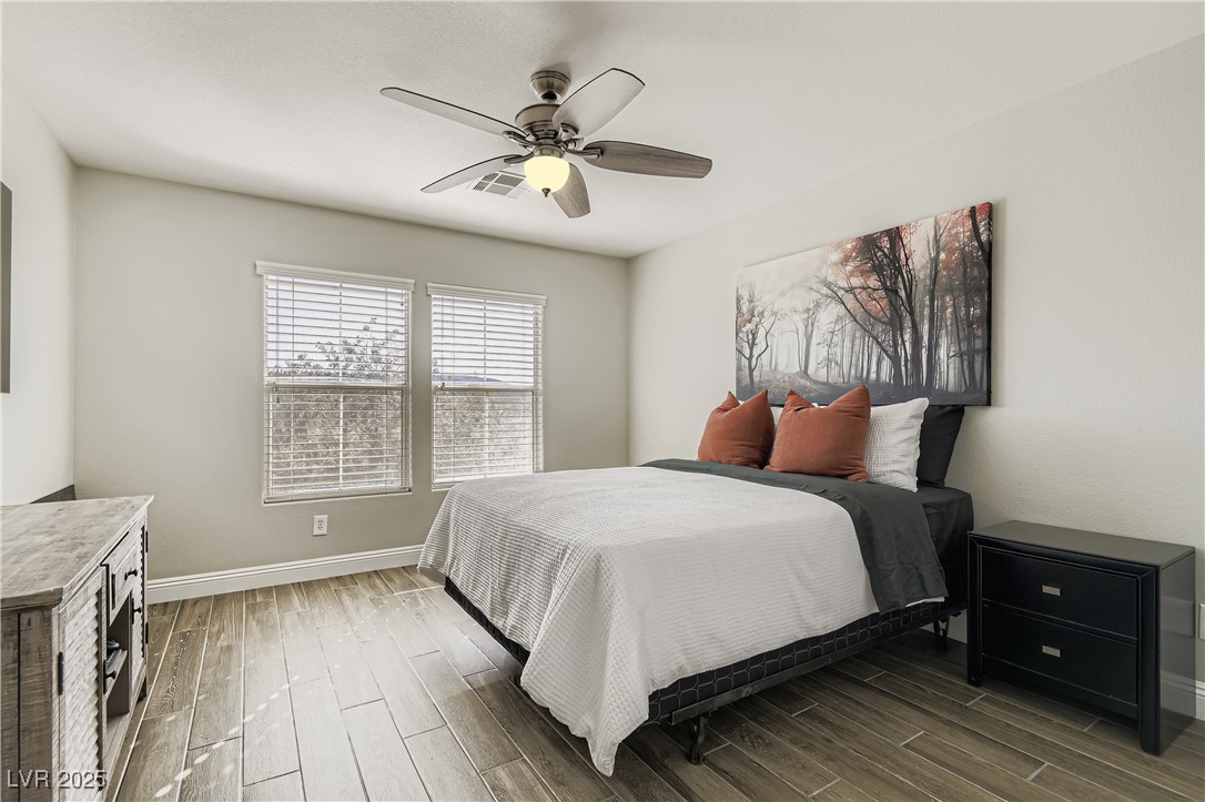7055 Fort Tule Avenue Las Vegas, NV 89179 - Photo 34 of 75 Bedroom with wood tile floors and a ceiling fan views of the mountains
