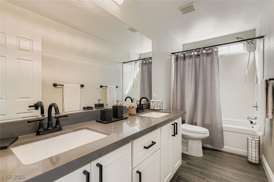 7055 Fort Tule Avenue Las Vegas, NV 89179 - Photo 36 of 75 Bathroom featuring shower / bath combination with tile finish floors, New double vanity, and a textured ceiling