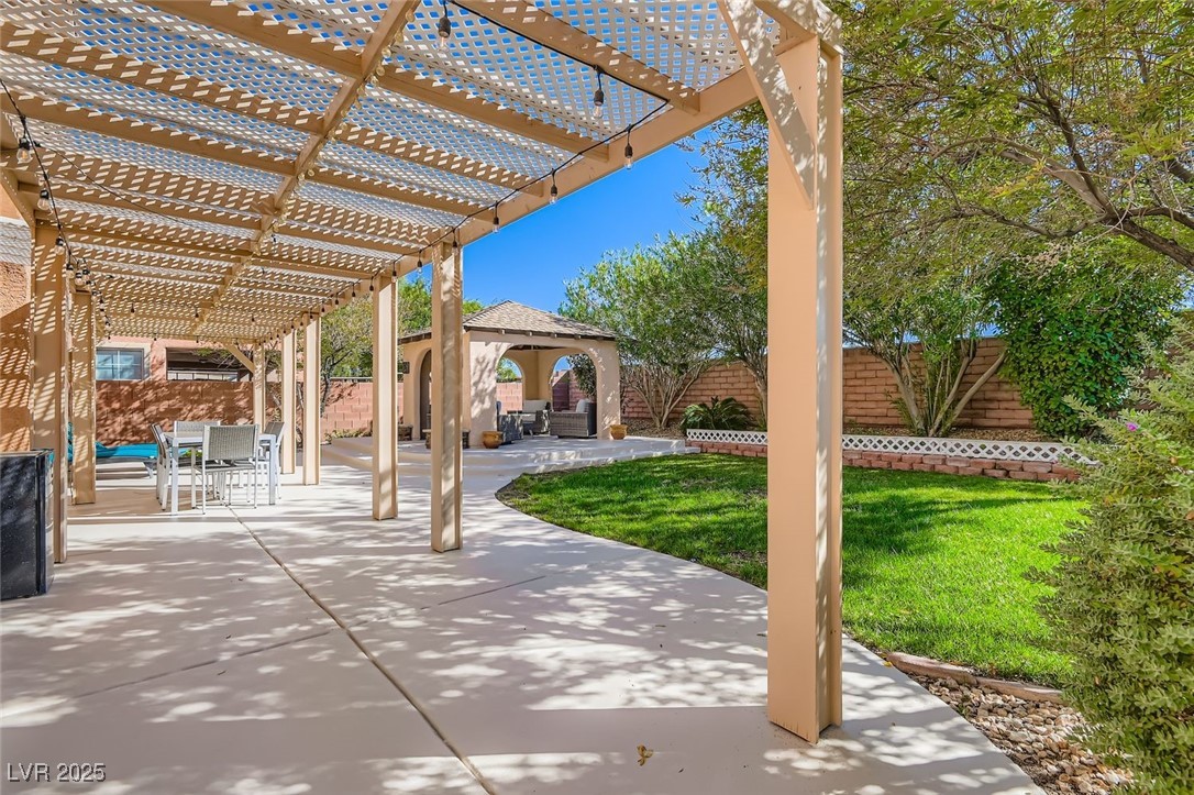 7055 Fort Tule Avenue Las Vegas, NV 89179 - Photo 40 of 75 Fenced backyard with a patio area, a gazebo, a pergola, and outdoor dining area