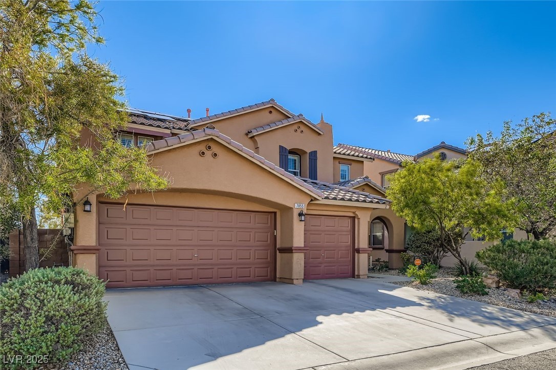7055 Fort Tule Avenue Las Vegas, NV 89179 - Photo 42 of 75 Mediterranean / spanish house featuring driveway, stucco siding, a tiled roof, and an attached garage