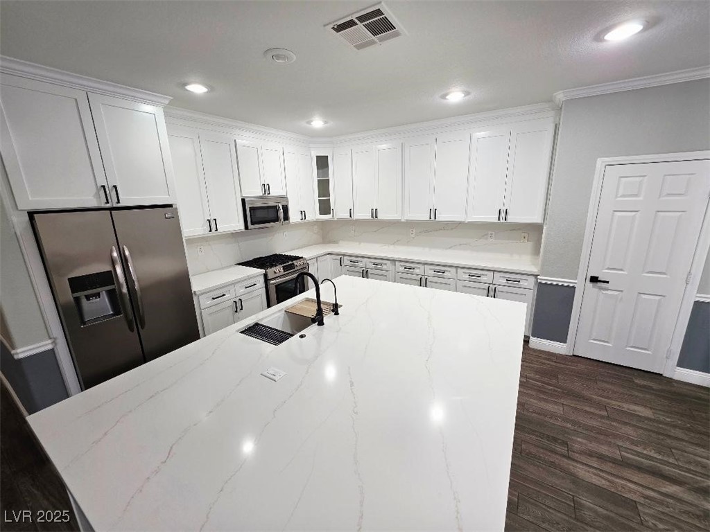7055 Fort Tule Avenue Las Vegas, NV 89179 - Photo 46 of 75 Kitchen featuring white cabinetry, light stone counters, stainless steel appliances, glass insert cabinets, and dark tile -style flooring