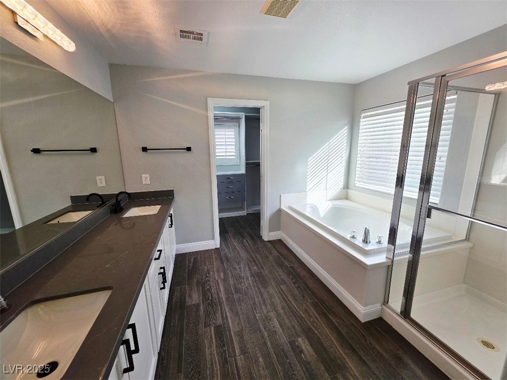 7055 Fort Tule Avenue Las Vegas, NV 89179 - Photo 69 of 75 Full bathroom with double vanity, a garden tub, dark tile finished floors, and a stall shower large walk-in closet
