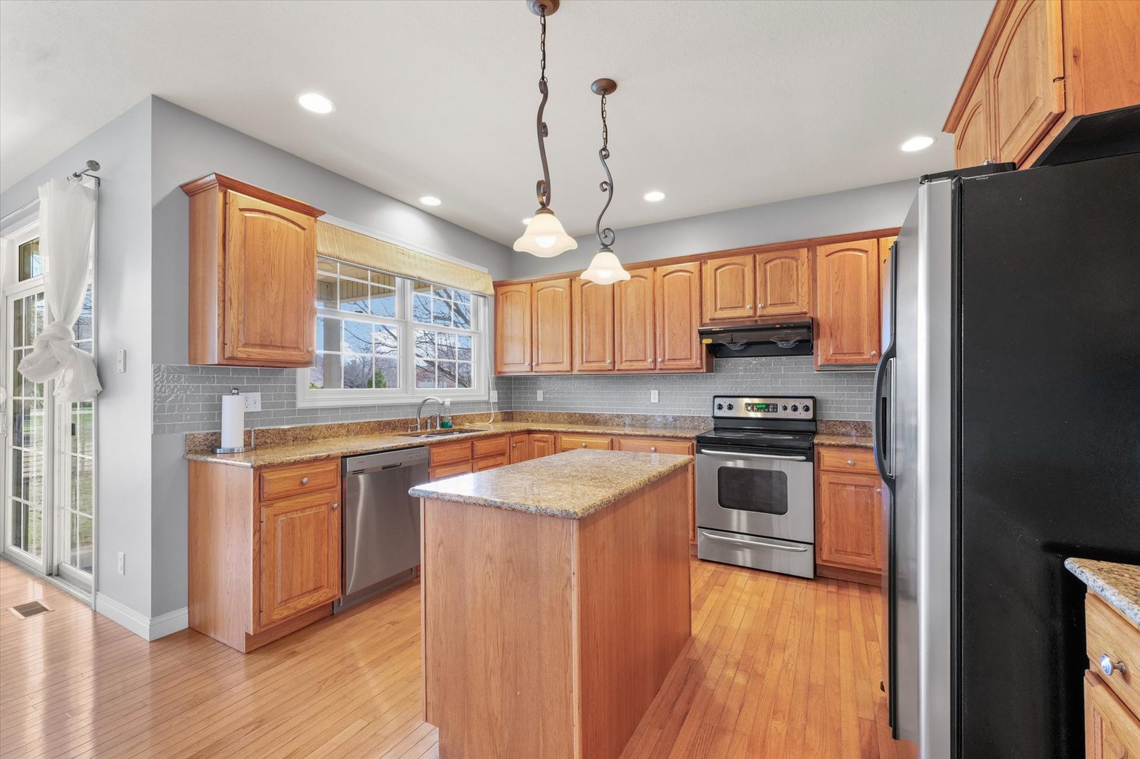 1818 Benodot Street Champaign, IL 61822 - Photo 8 of 41 a kitchen with stainless steel appliances granite countertop a stove a sink dishwasher a refrigerator white cabinets and wooden floor