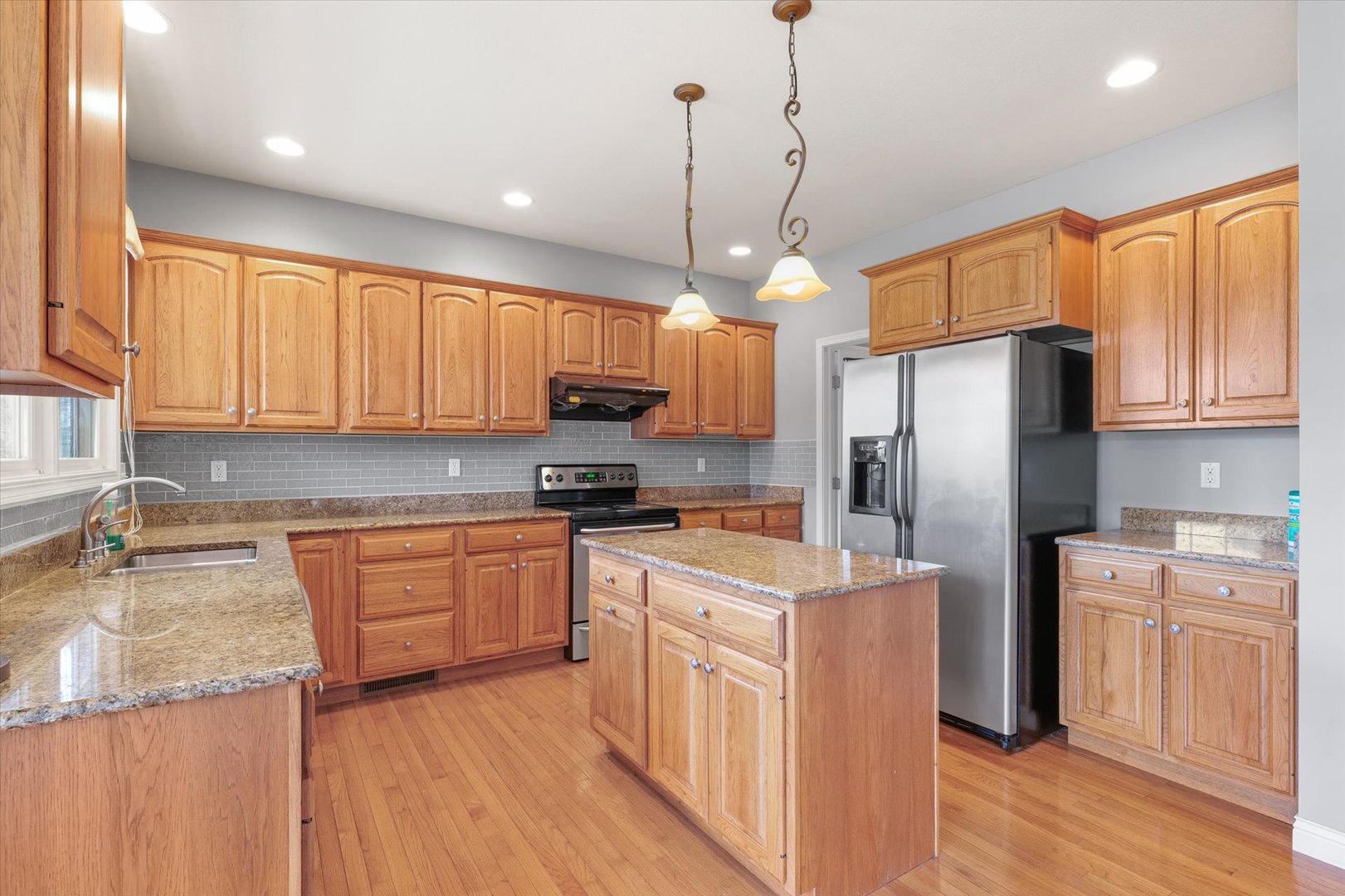 1818 Benodot Street Champaign, IL 61822 - Photo 9 of 41 a kitchen with stainless steel appliances granite countertop a refrigerator a sink dishwasher a stove and white cabinets with wooden floor