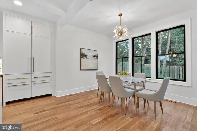 a dining room with furniture potted plants and wooden floor