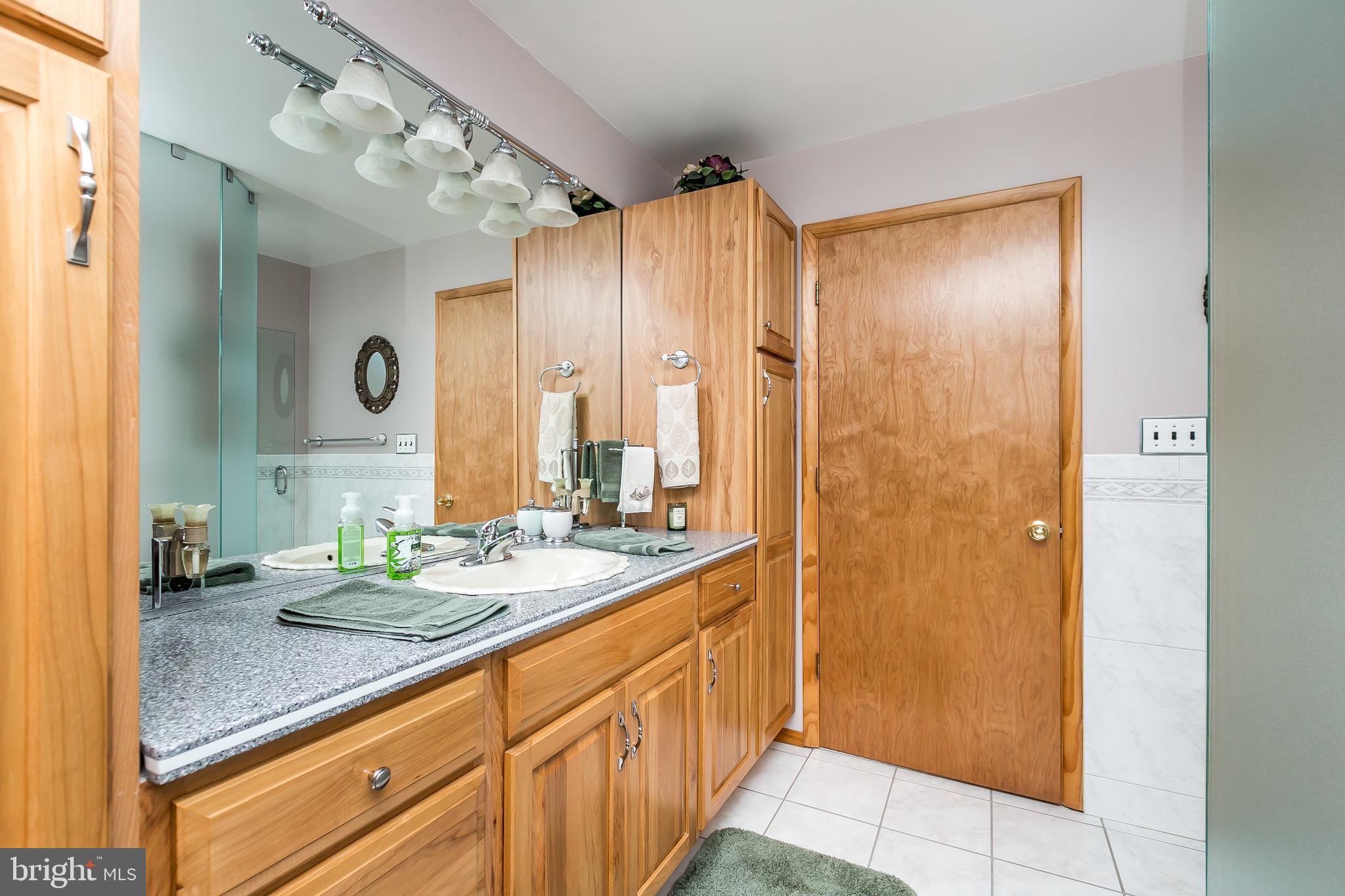 2507 Maple Road Baltimore, MD 21219 - Photo 14 of 29 a bathroom with a granite countertop sink a mirror and a shower