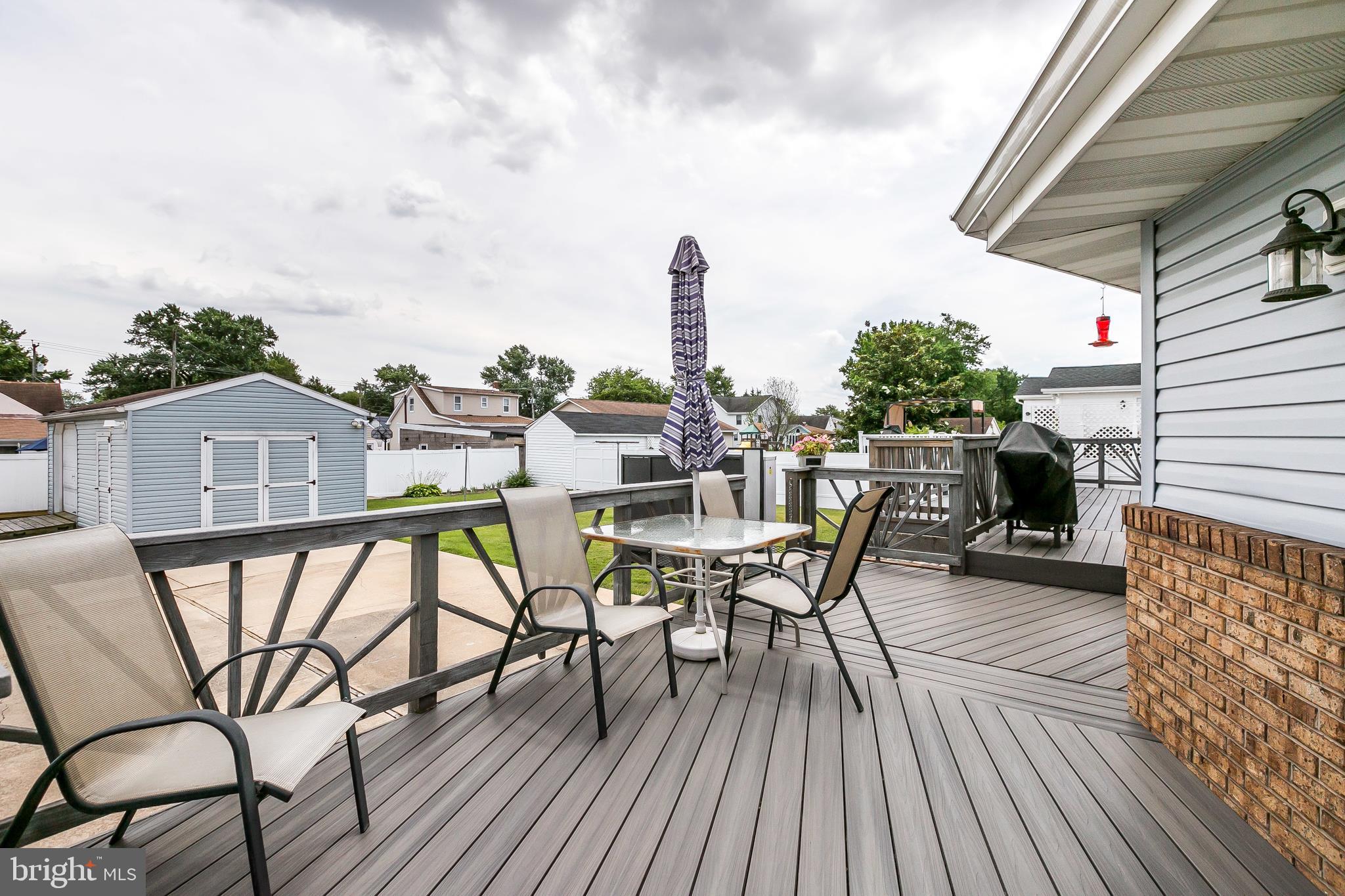 2507 Maple Road Baltimore, MD 21219 - Photo 28 of 29 a view of a roof deck with table and chairs a barbeque with wooden floor and fence