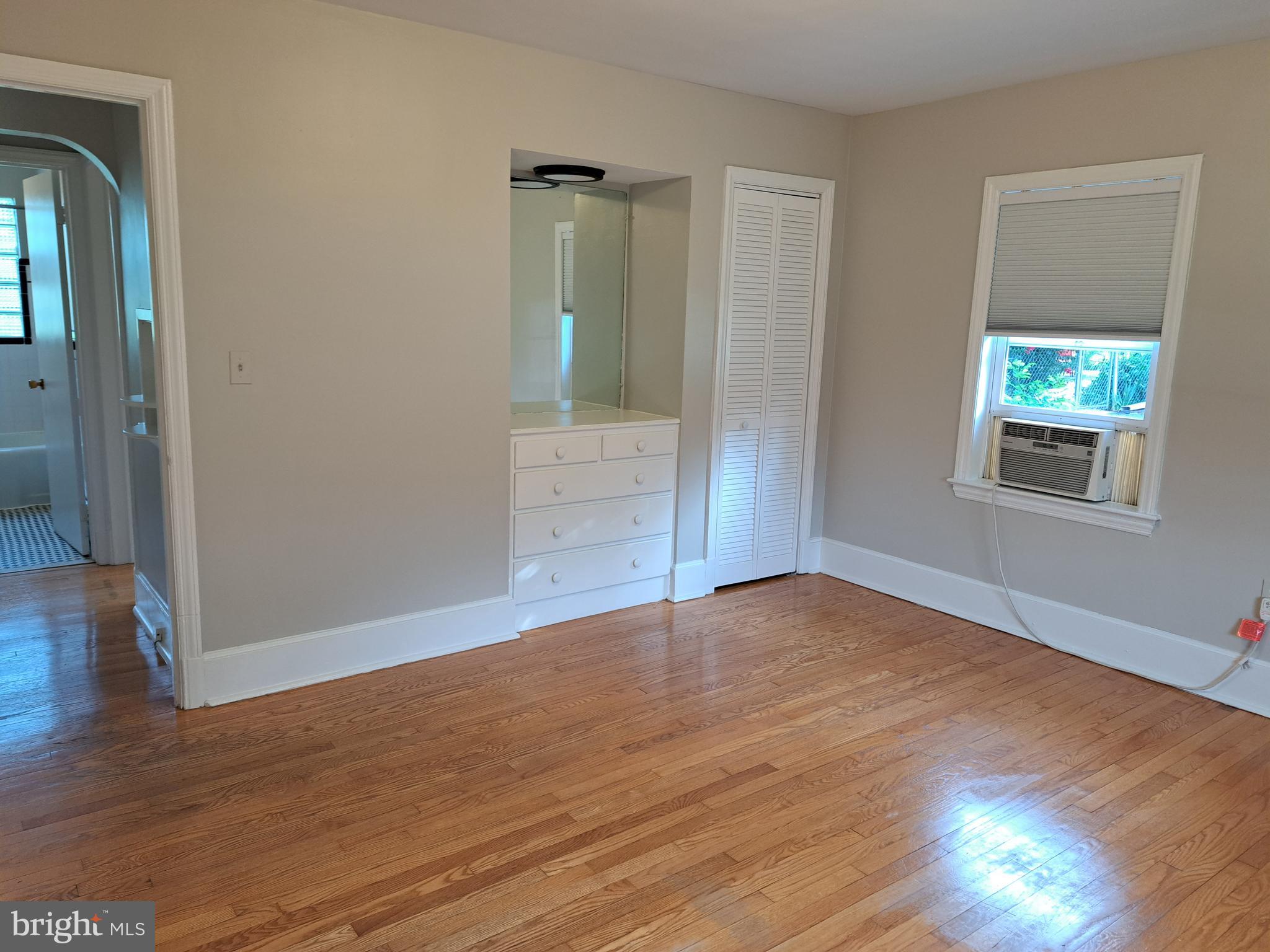 415 Biggs Avenue, Unit 1 Frederick, MD 21702 - Photo 6 of 29 a view of an empty room with wooden floor and a window
