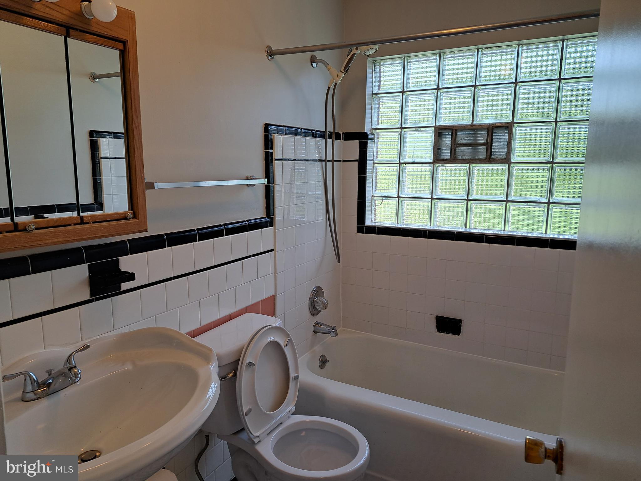 415 Biggs Avenue, Unit 1 Frederick, MD 21702 - Photo 9 of 29 a bathroom with a sink toilet a mirror and shower
