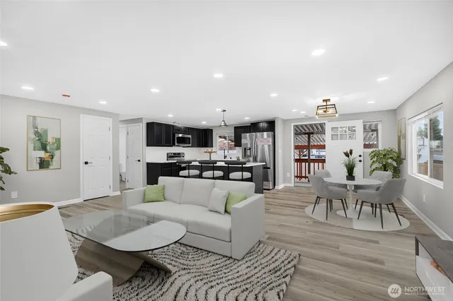 a living room with furniture and view of kitchen