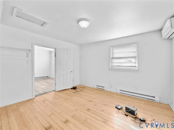 a view of a room with a bed and wooden floor