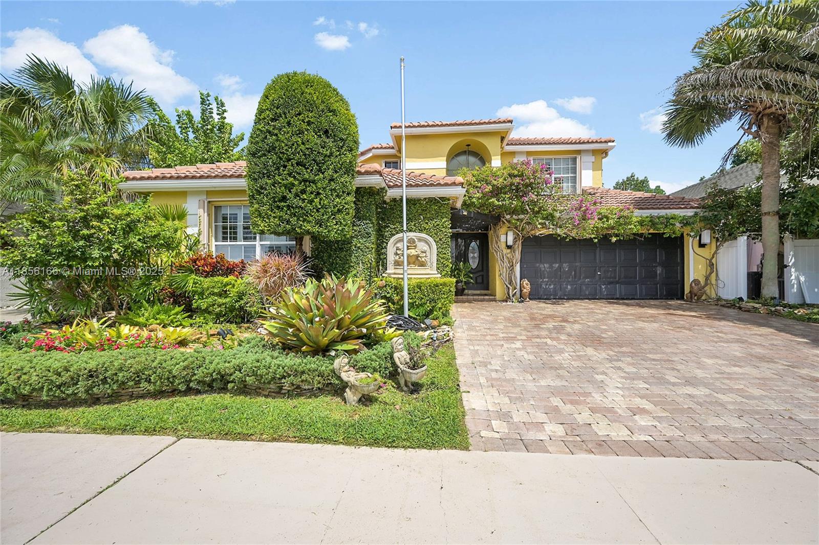 9398 Aegean Drive Boca Raton, FL 33496 - Photo 2 of 61 a view of a white house with a yard and potted plants