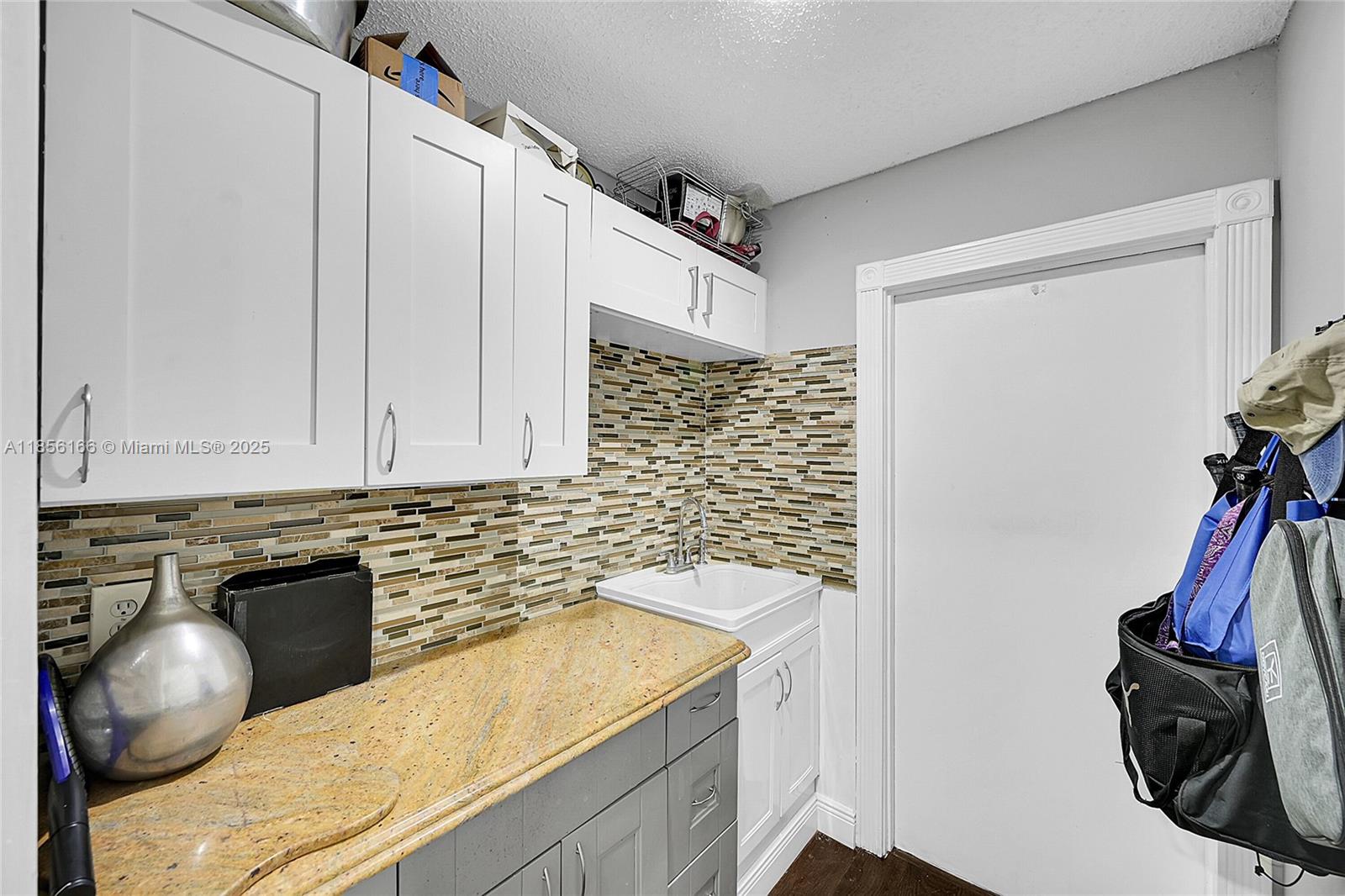 9398 Aegean Drive Boca Raton, FL 33496 - Photo 27 of 61 a kitchen with granite countertop a sink a stove and a wooden cabinets