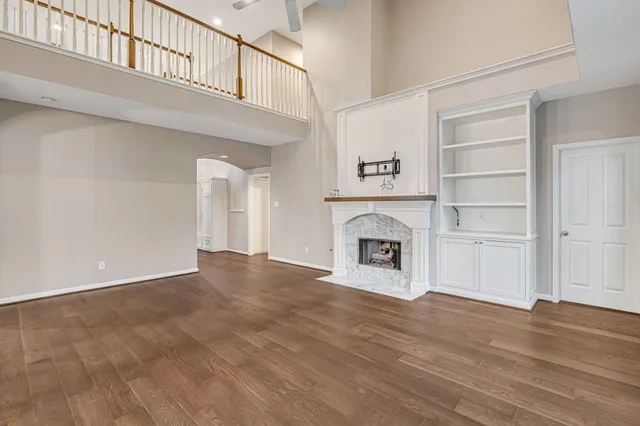 a view of an empty room with a fireplace and a window
