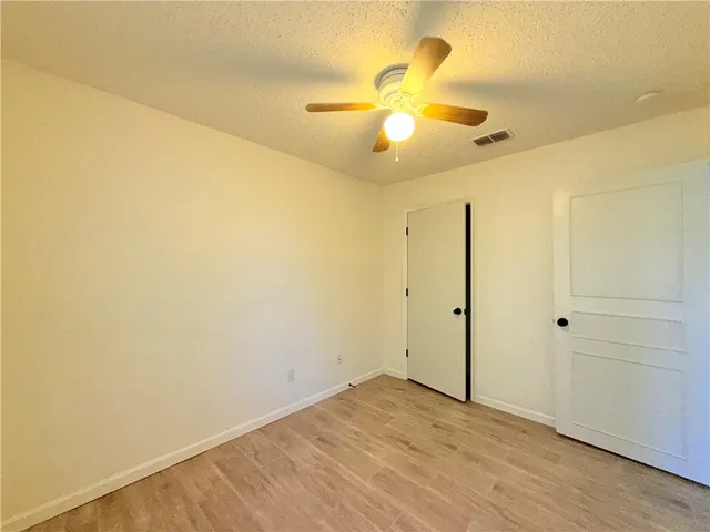 an empty room with a fan and a fan