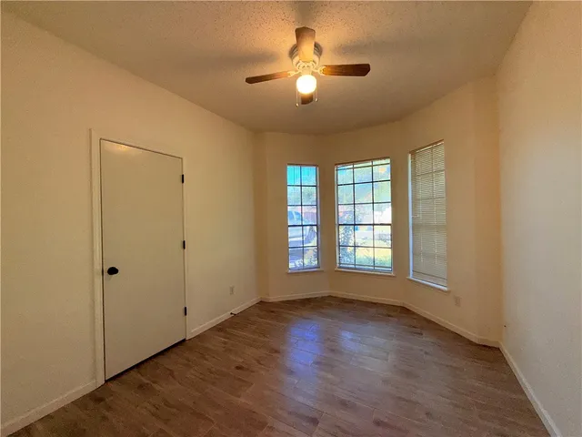 a view of wooden floor and a chandelier fan in a room