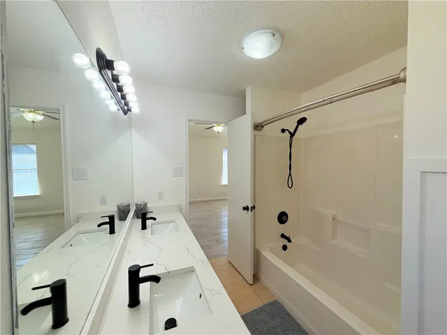 a bathroom with a tub sink mirror and shower