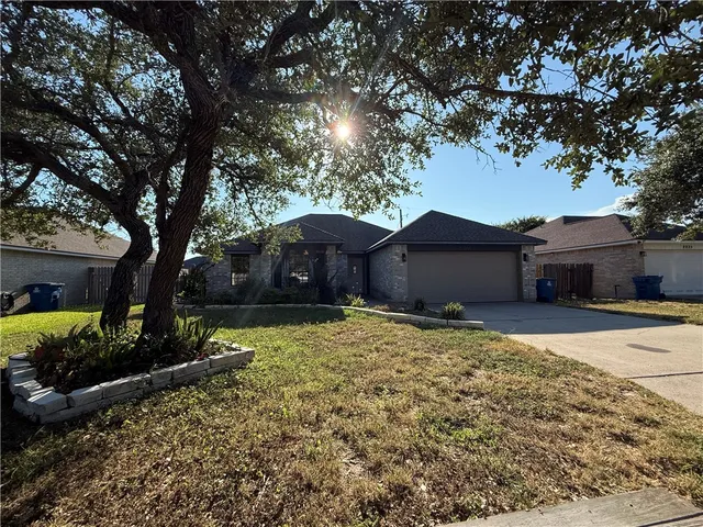 a front view of house with yard and trees