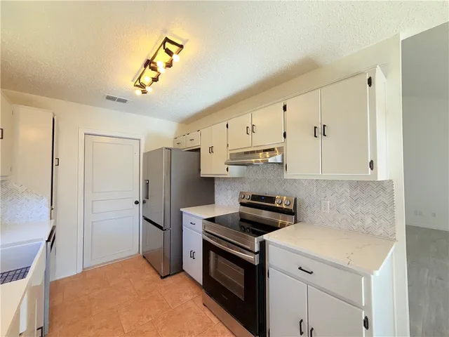 a kitchen with stainless steel appliances a refrigerator sink and cabinets