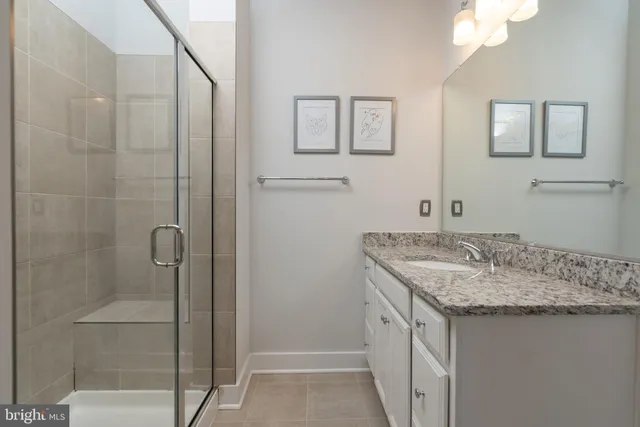 a bathroom with a granite countertop sink and mirror