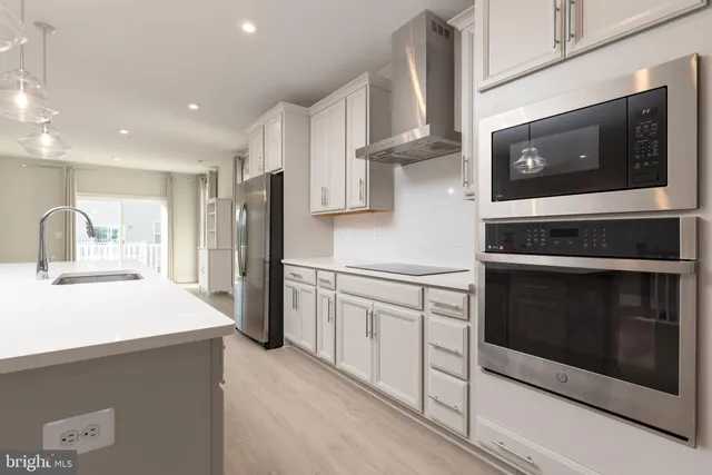 a kitchen with stainless steel appliances a stove microwave and refrigerator