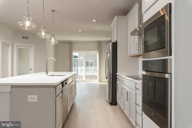 a kitchen with stainless steel appliances granite countertop a sink and a refrigerator