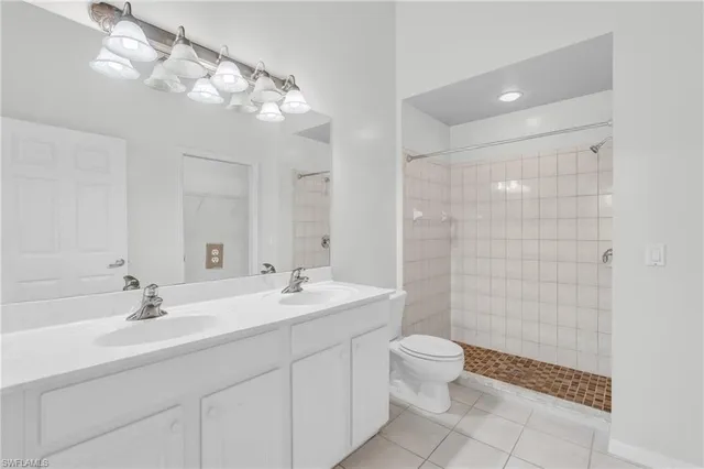 a bathroom with a double vanity sink mirror and toilet