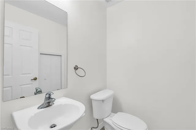 a bathroom with a sink mirror and toilet