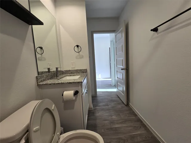 a bathroom with a granite countertop sink a toilet and shower