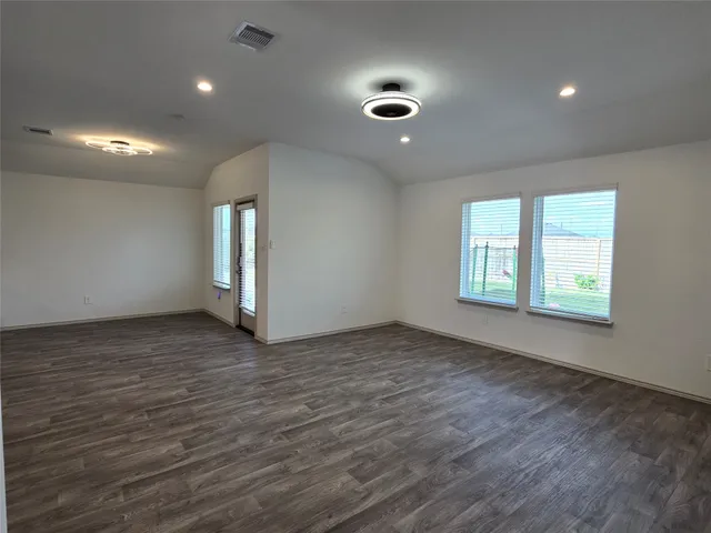 a view of kitchen with kitchen island granite countertop stainless steel appliances refrigerator and microwave