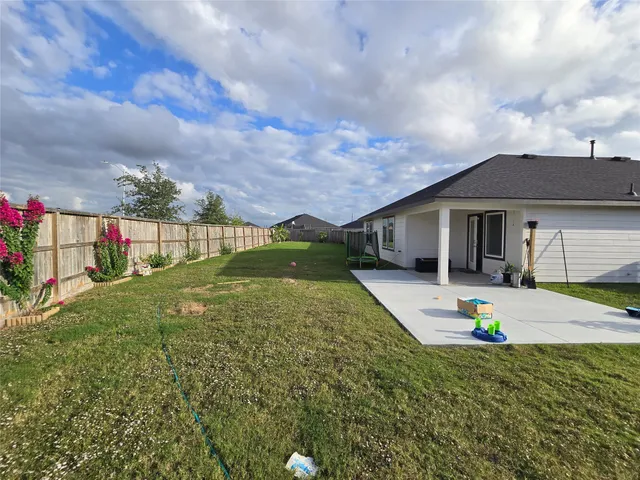 a view of a garden with a bench in front of the house