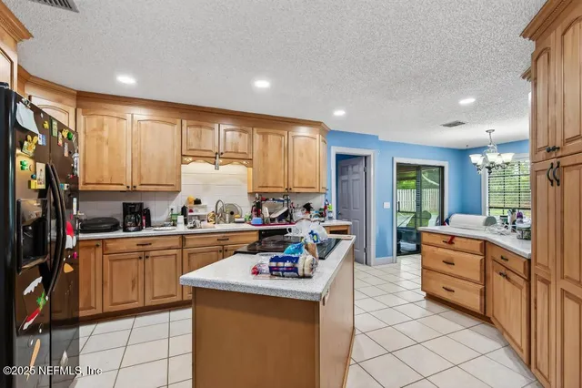 a kitchen that has a lot of cabinets in it and wooden floors