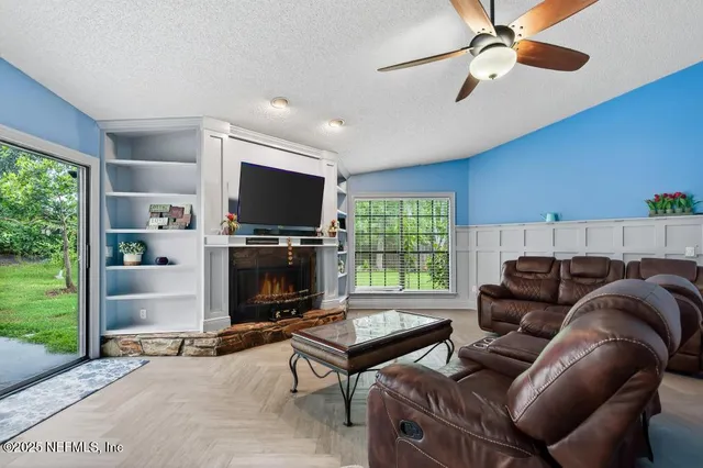 a living room with furniture a flat screen tv and a fireplace