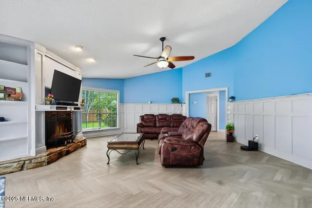 a living room with furniture a flat screen tv and a fireplace
