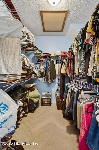 a view of walk in closet with clothes and shoes