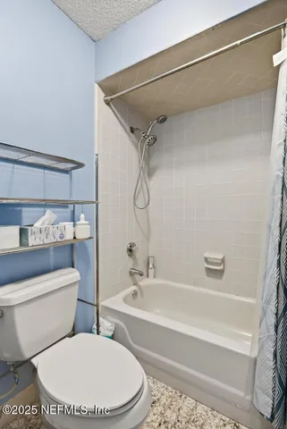 a bathroom with a toilet and a bath tub