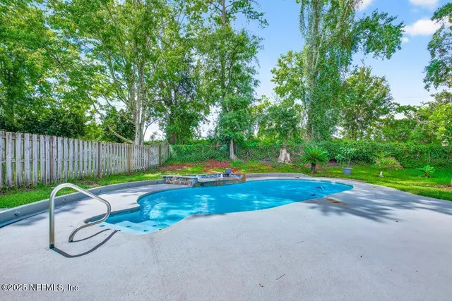 a view of backyard with swimming pool and outdoor seating