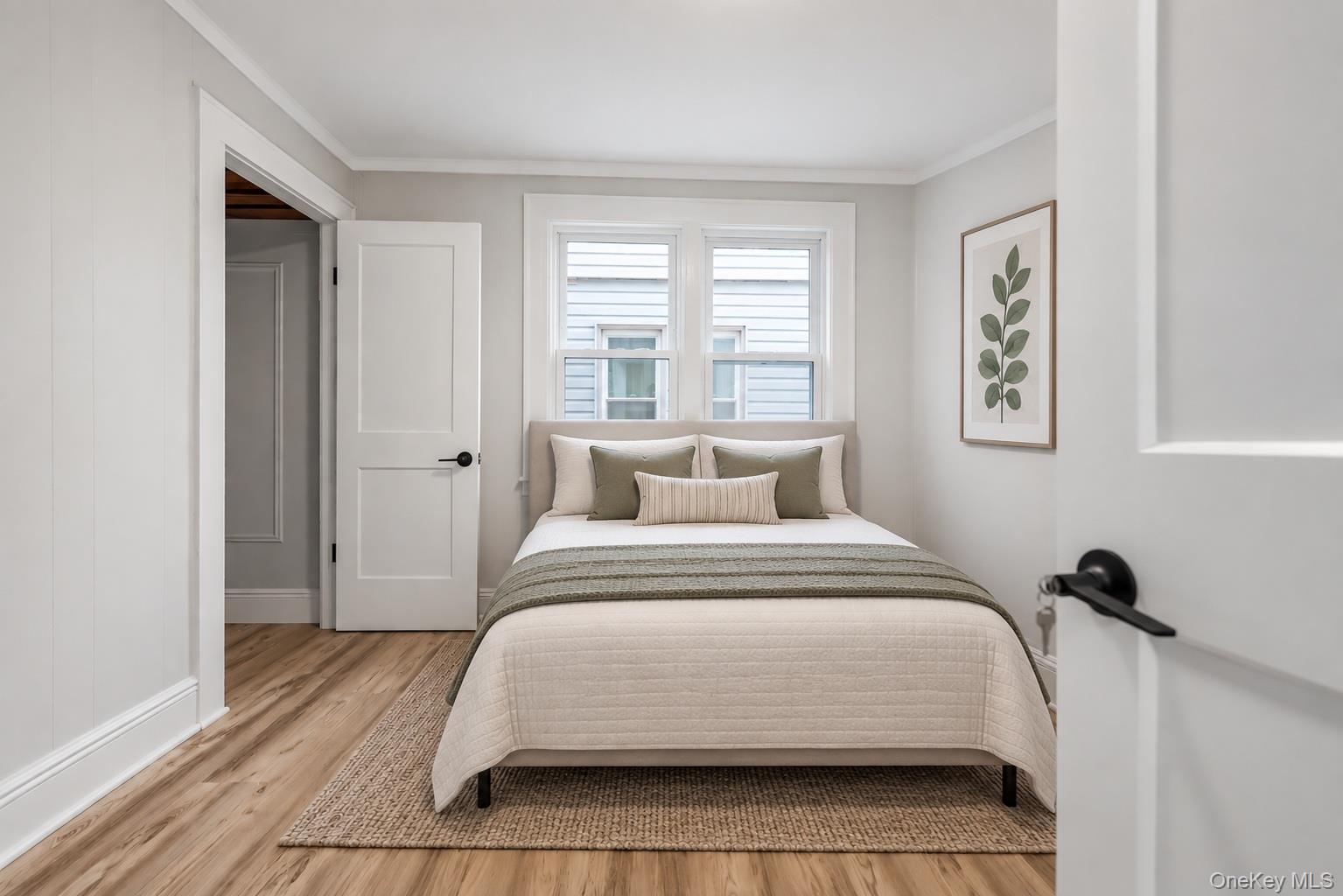 173-43 103rd Road Queens, NY 11433 - Photo 26 of 43 Wood-finish flooring, white paneled walls, white trim, matte black door hardware, and double windows