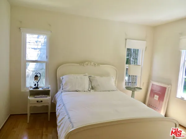 a bed sitting in a bedroom next to a window