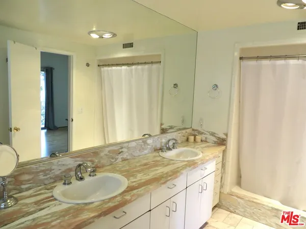 a bathroom with a granite countertop sink and a mirror