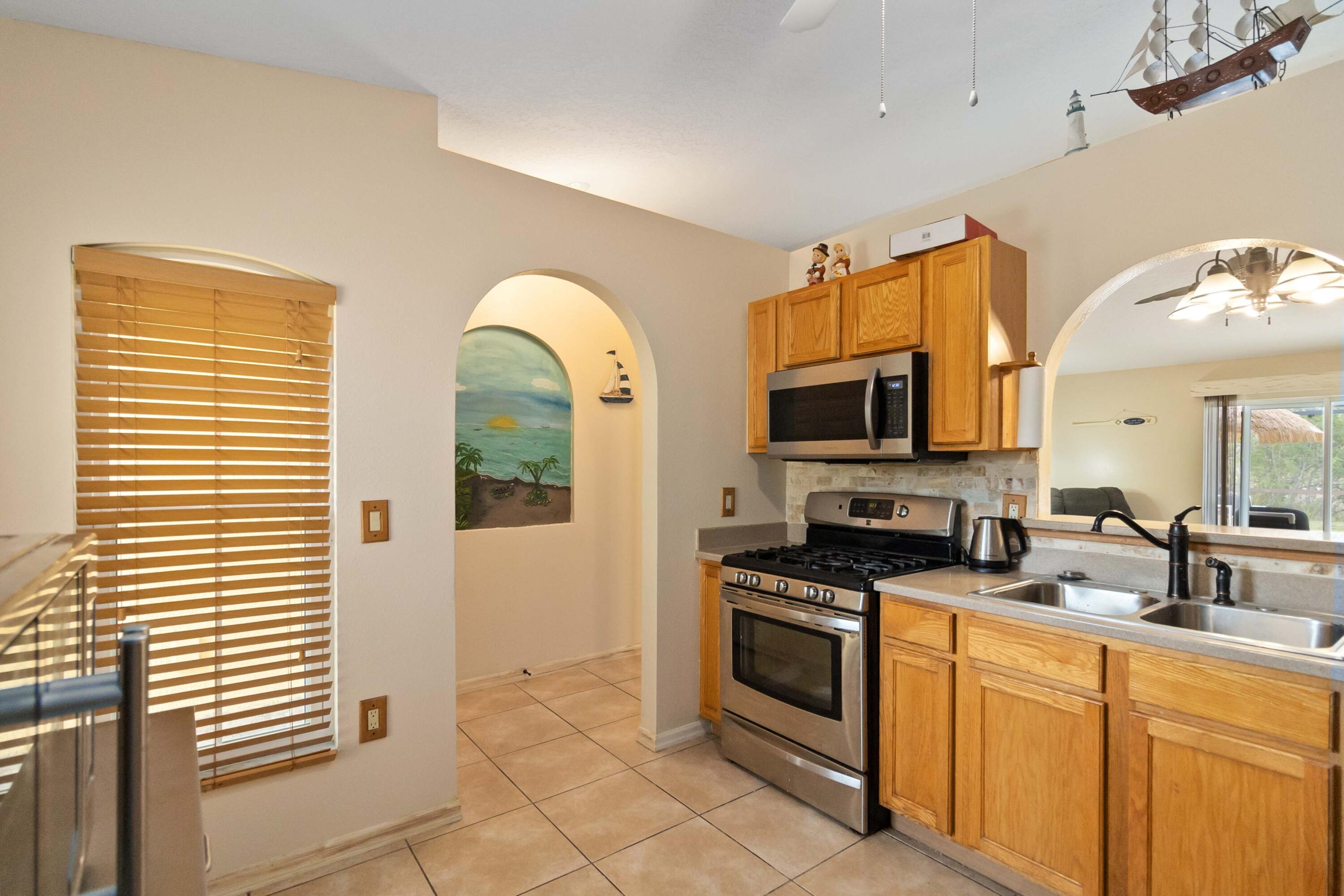 1364 Ran Road Southeast Palm Bay, FL 32909 - Photo 12 of 26 a kitchen with stainless steel appliances granite countertop a stove a sink and a microwave