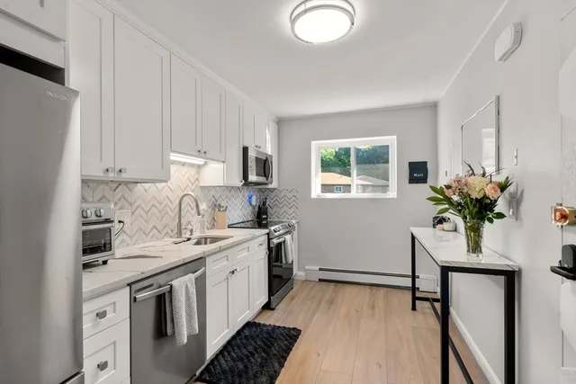 a kitchen with a white stove top oven and white cabinets