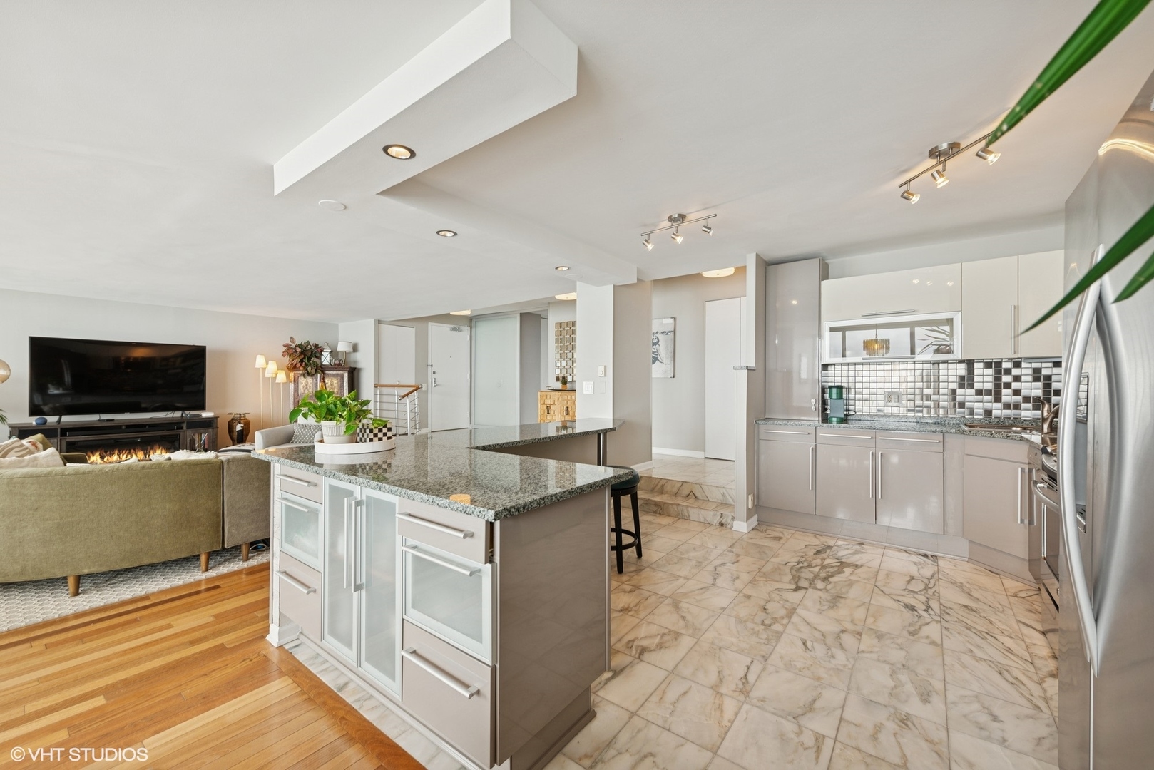 5733 North Sheridan Road, Unit 29D Chicago, IL 60660 - Photo 12 of 40 a large white kitchen with cabinets and wooden floor