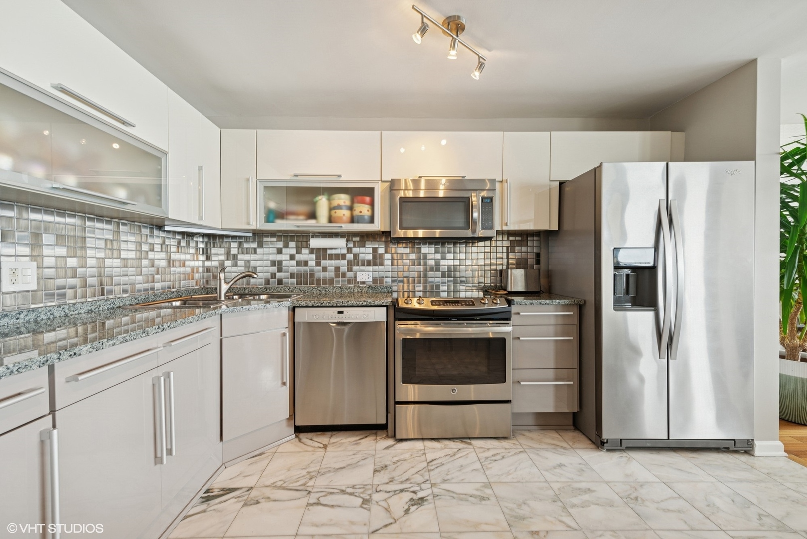 5733 North Sheridan Road, Unit 29D Chicago, IL 60660 - Photo 9 of 40 a kitchen with stainless steel appliances granite countertop a refrigerator sink and stove