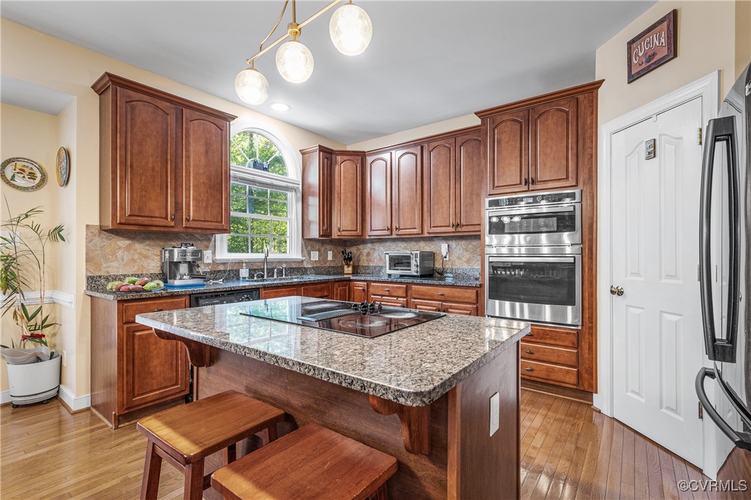 3541 Kings Farm Drive Midlothian, VA 23113 - Photo 13 of 49 a kitchen with stainless steel appliances granite countertop a stove top oven a refrigerator a sink and dishwasher with wooden floor