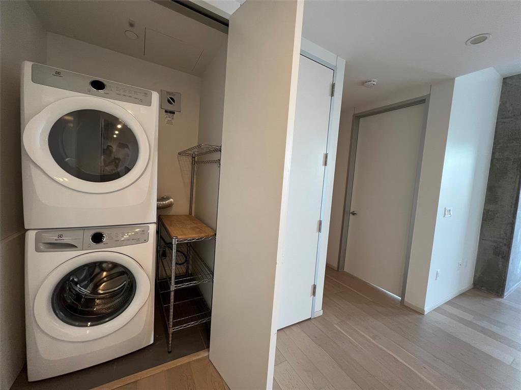 301 West Avenue, Unit 1502 Austin, TX 78701 - Photo 6 of 26 Laundry room featuring light wood-type flooring and stacked washer and clothes dryer