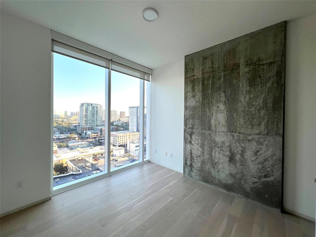301 West Avenue, Unit 1502 Austin, TX 78701 - Photo 10 of 26 Empty room with a view of city, expansive windows, and light wood-type flooring