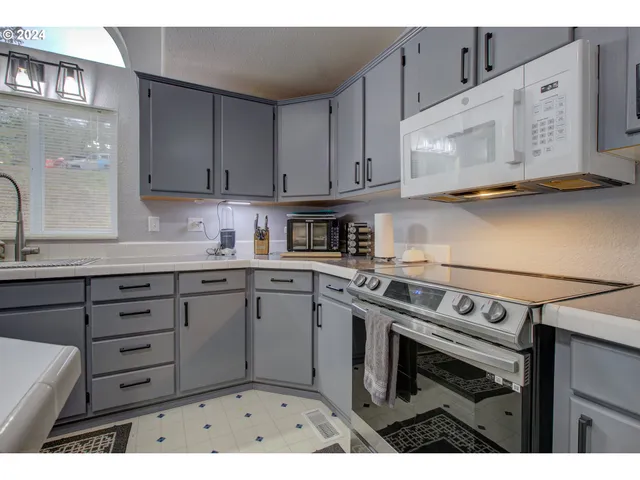 a kitchen with stainless steel appliances granite countertop a sink stove and cabinets