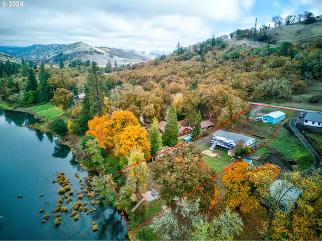 an aerial view of residential houses with outdoor space and trees