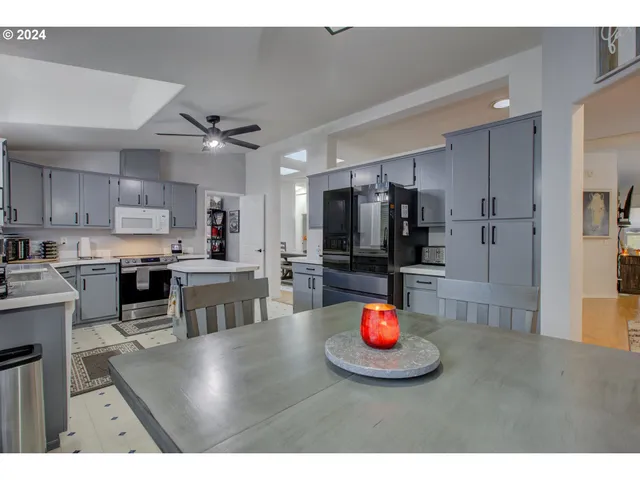 a kitchen with kitchen island stainless steel appliances a sink counter space and a refrigerator